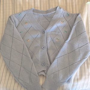 light blue sweater, with embroidered flowers
